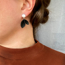 Kaima Designin Varpu-malliston pieni musta korvakoru mallin päällä.