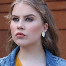 Tyttö, jolla korvassa Bloom -malliston kultainen nappikorvakoru,