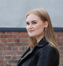 Kaima Designin Bloom -malliston mustan ja hopean värinen nappikorvakoru mallin päällä, käsintehty poronnahasta.