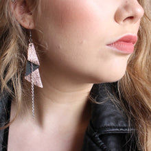 Lähikuva naisesta, jolla korvassa iso ruusukultainen Kelo -korvakoru.kor