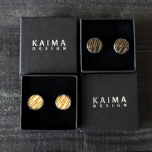 Kelo -malliston isot nappikorvakorut, väreissä puu ja musta.