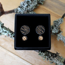 Kelo -malliston nappikorvakorusetti, jossa iso musta ja pieni puun värinen nappikorvakoru.