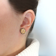 Lähikuva tytöstä, jolla on korvassa Kelo-sarjan puun värinen iso nappikorvakoru.